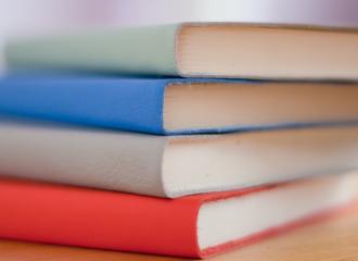 Pile of books with a pale green, blue, grey and red covers