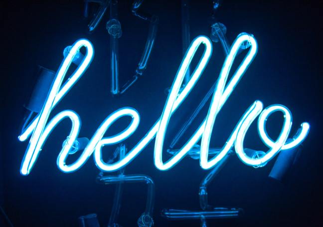 Picture of blue neon light on dark background spelling 'hello'