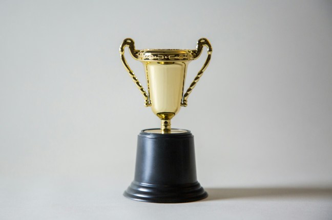 A gold trophy on a plain background